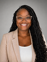 Woman with dark hair and glasses smiling at camera
