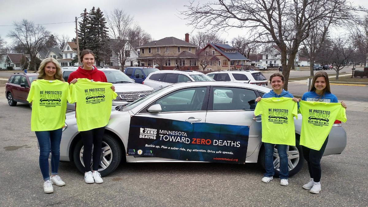 Teen drivers showing shirts promoting buckling up